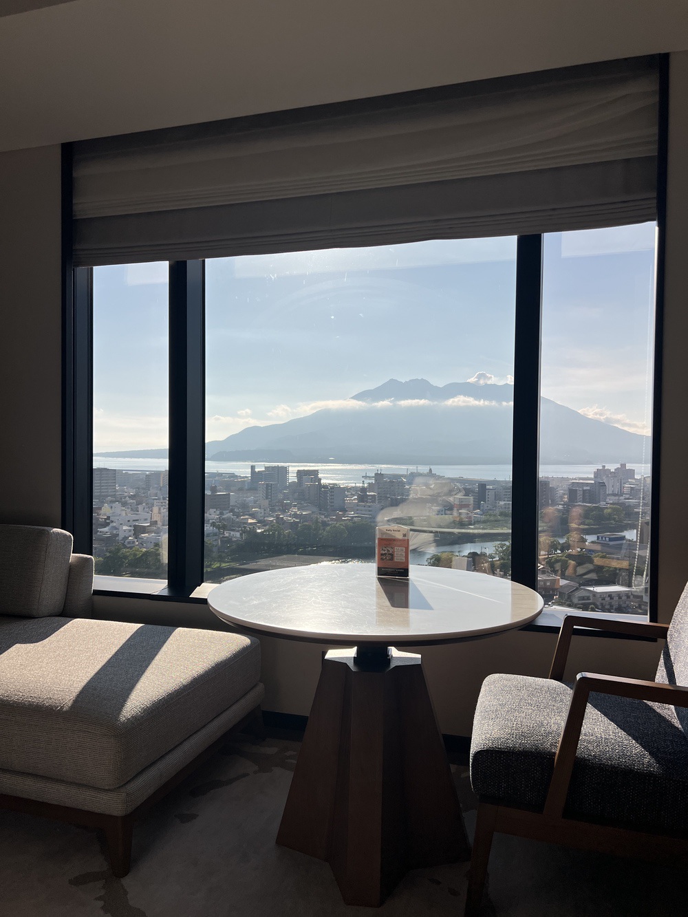 Coin salon face à la fenêtre avec vue sur le volcan Sakurajima