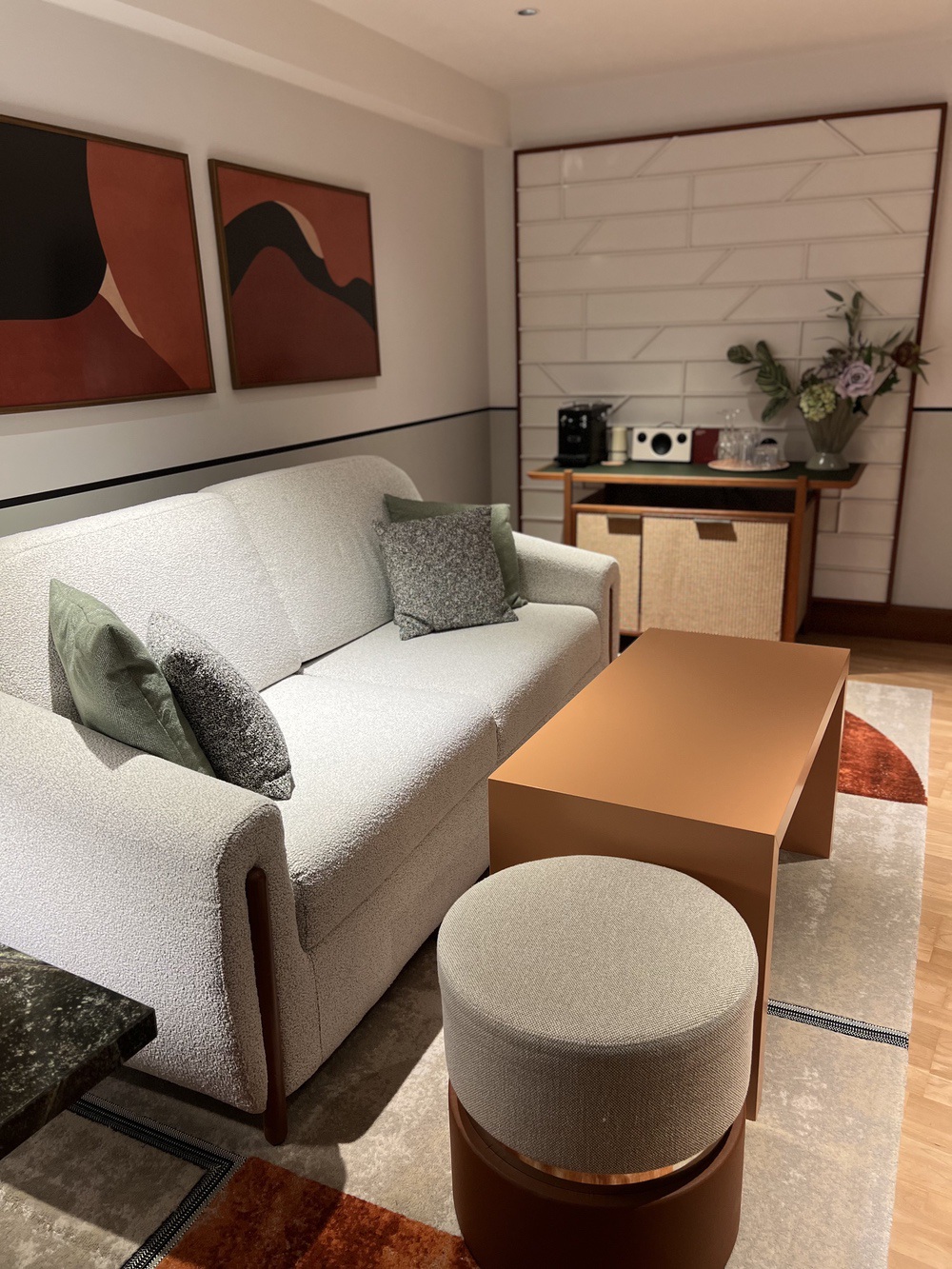 Salon cosy de la suite junior avec canapé bouclé et art mid-century