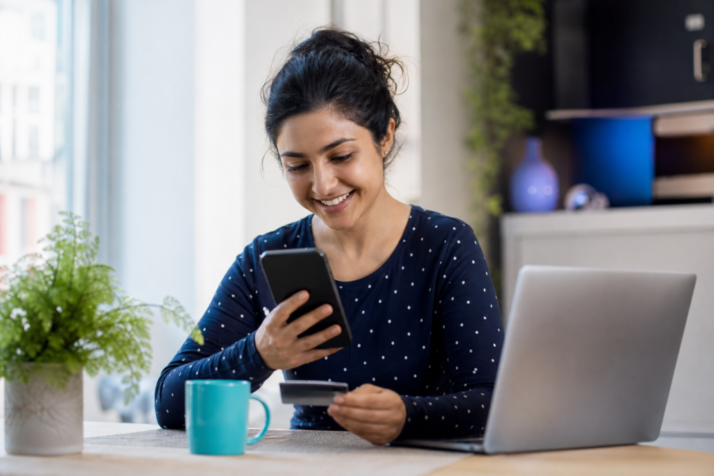 Femme souriante consultant l'application bancaire Neo sur son téléphone en tenant une carte de crédit