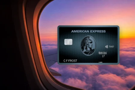 Carte Cobaltᴹᴰ American Express devant un hublot d'avion au lever du soleil