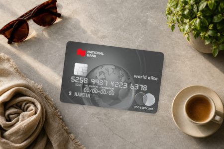 National Bank World Elite Mastercard resting on marble next to sunglasses and a coffee