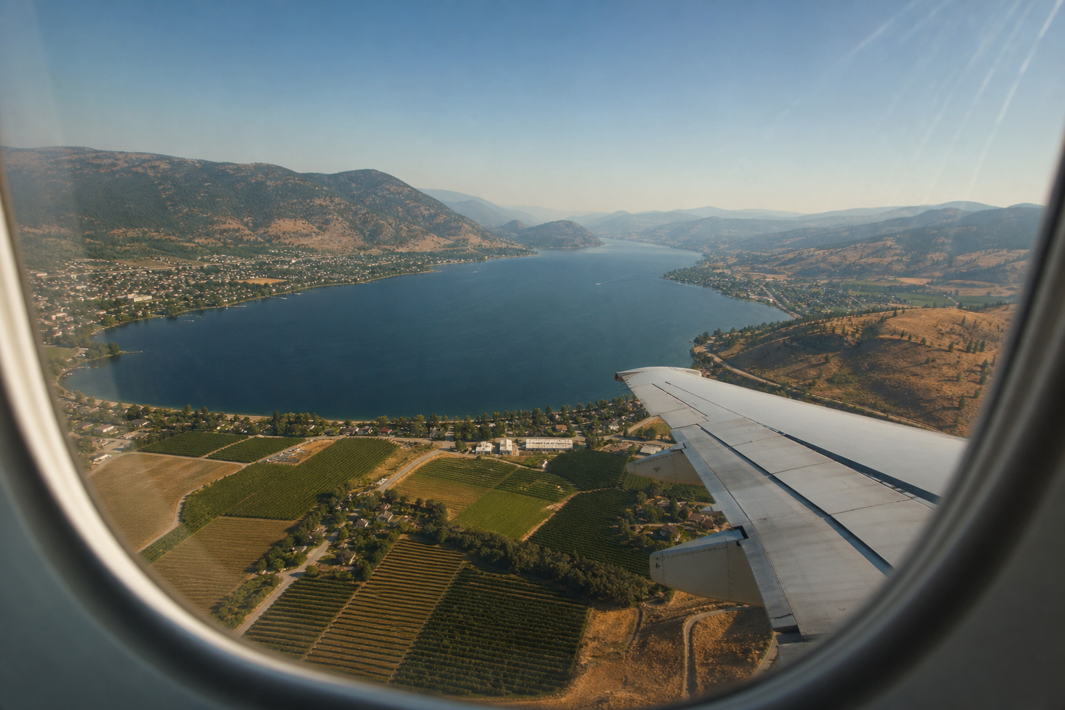 Guide complet de l'aéroport de Kelowna (YLW) - Vallée de l'Okanagan vue du hublot à l'approche, avec le lac, les vignobles et les collines dorées